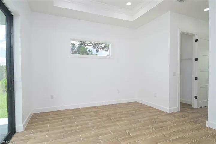 Unfurnished room with ornamental molding and a tray ceiling