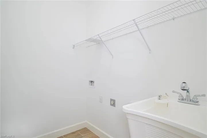 Laundry room featuring hookup for a washing machine, electric dryer hookup, and sink