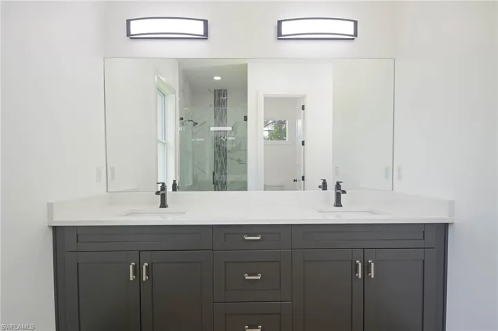 Bathroom with a shower with door and dual bowl vanity