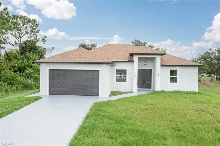 View of front of home with a garage and a front yard