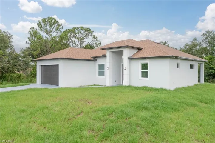 View of front facade featuring a garage and a front yard