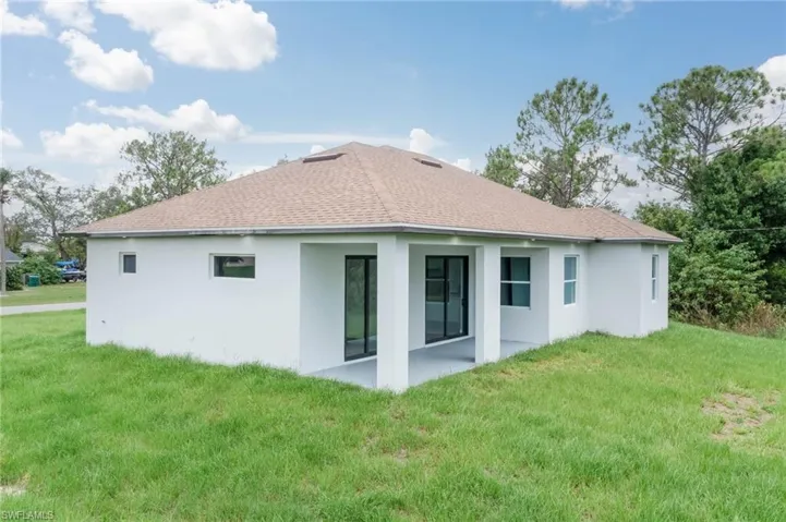 Rear view of property with a yard