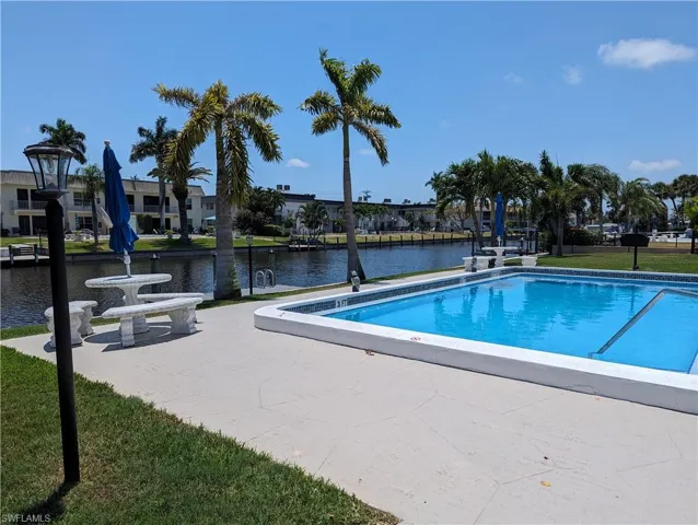 Community pool with a yard, a water view, and a patio area