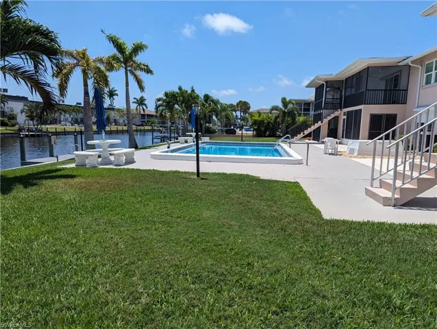 Outdoor pool with a patio and a yard