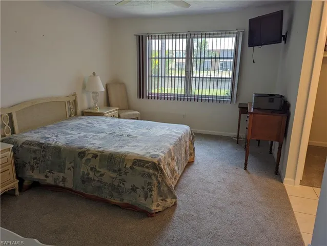 Bedroom with light carpet and a ceiling fan