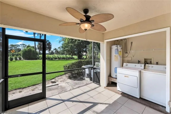 Screened patio featuring a ceiling fan, tile flooring, and integrated laundry area with hookups and water heater