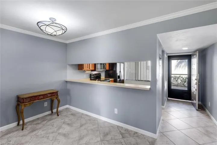 Dining area with light gray walls and crown molding