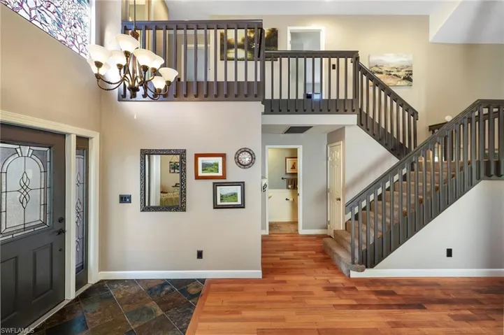 Foyer tile and wood flooring, 2 story high ceiling, staircase to loft, 3 bedrooms and full bathroom