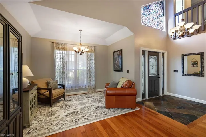 Entryway with a raised ceiling, wood floors in living room