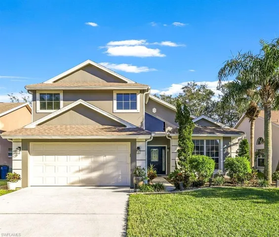 View of front of home featuring a front yard and a garage