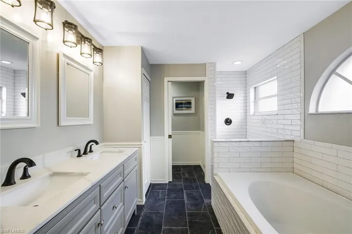 Bathroom with tile floors, wood vanities, and tiled walk-in shower, flooring, separate garden bathtub, linen closet, pocketing door to water closet