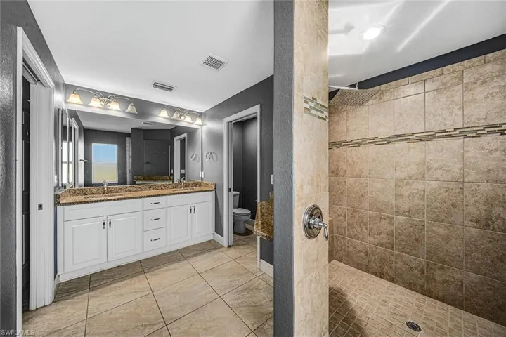 Bathroom featuring double vanity and a walk in shower