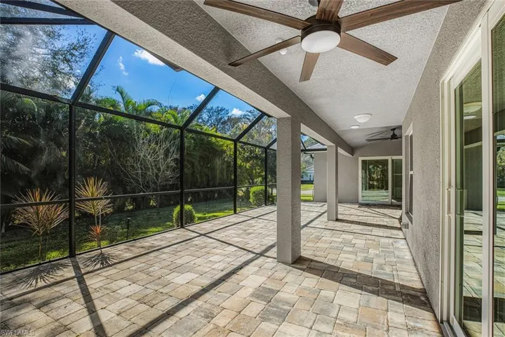 Unfurnished sunroom with a patio area and a ceiling fan