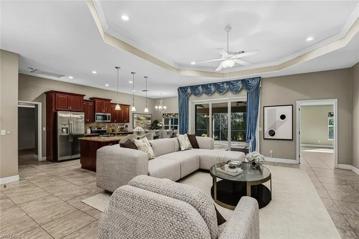 Living area featuring crown molding, ceiling fan, and hanging lights