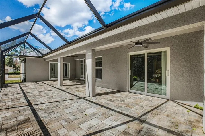 Unfurnished sunroom featuring a ceiling fan and a patio area