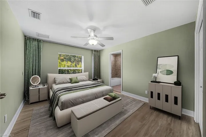 Bedroom with wood finished floors, a ceiling fan, and connected bathroom