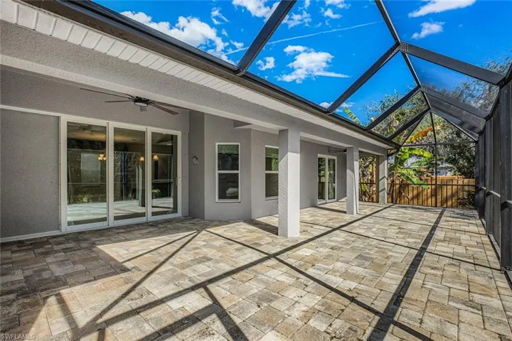 Unfurnished sunroom with a ceiling fan and a patio area