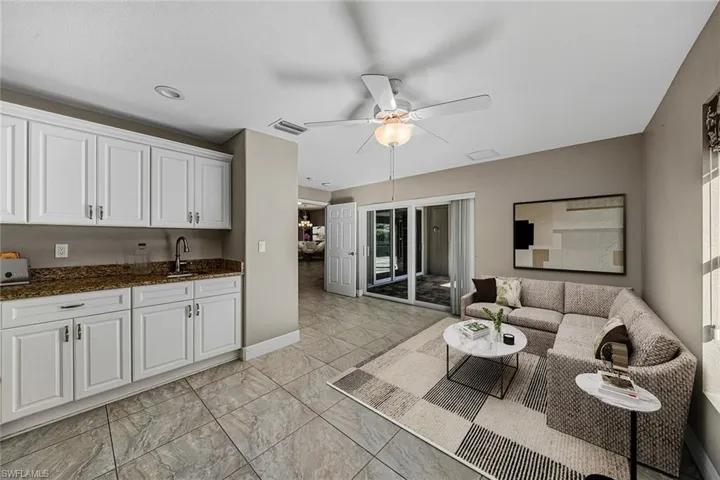 Living room featuring ceiling fan and light marble finish flooring