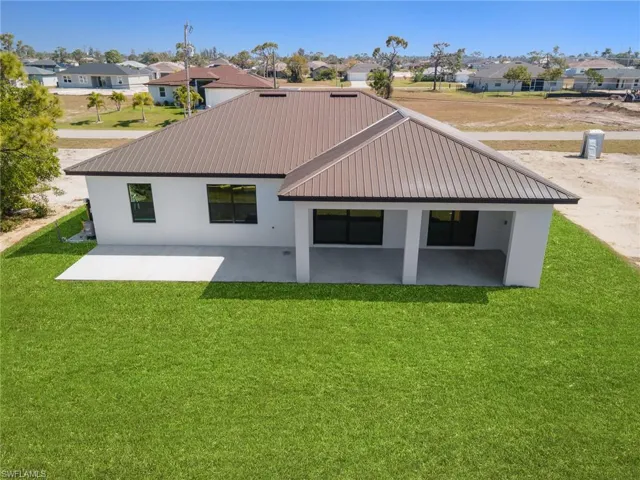 Rear view of property with a yard and a patio