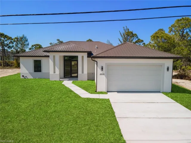 View of front of home with a front yard and a garage