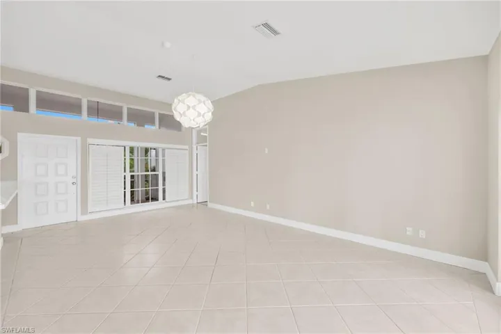 Unfurnished room featuring lofted ceiling and light tile patterned flooring