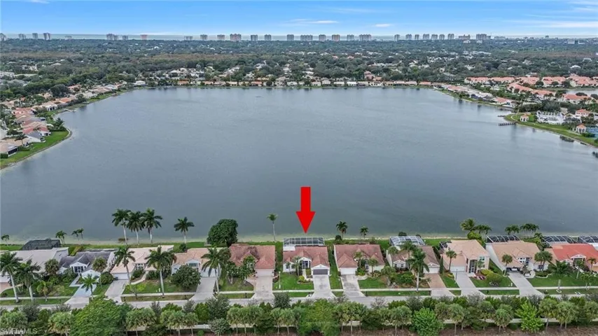 Aerial overview of property's location featuring skyline, a nearby body of water, and nearby suburban area