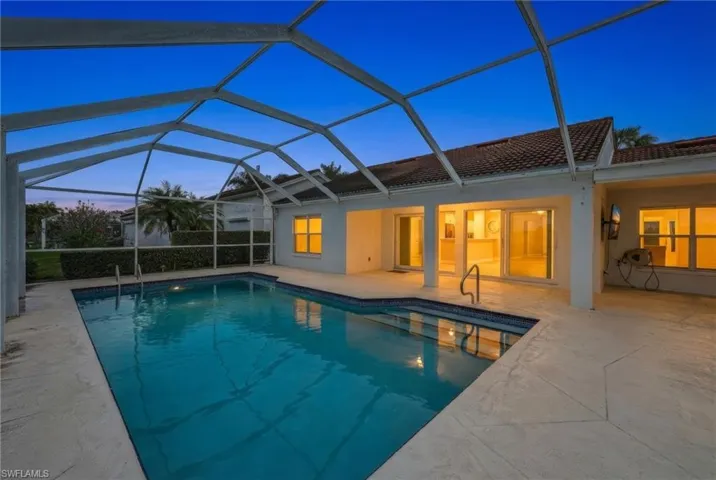 Swimming pool with a sunroom, a lanai, and a patio