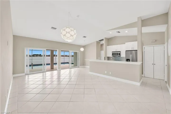 Unfurnished living room featuring lofted ceiling and light tile patterned floors