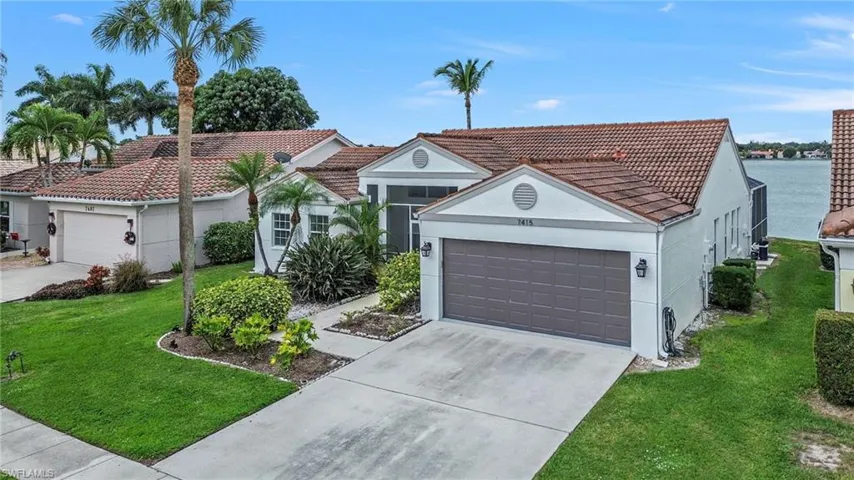 View of front of property with a front yard, stucco siding, an attached garage, driveway, and a tile roof
