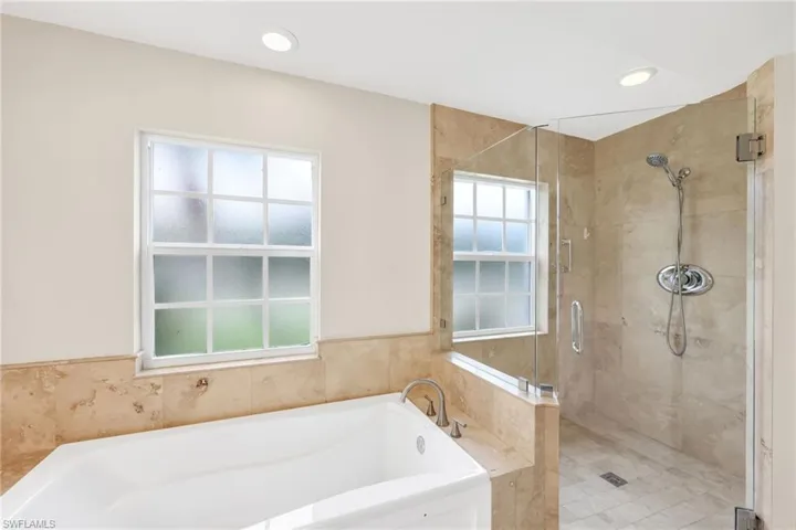 Bathroom with a garden tub, a stall shower, and recessed lighting