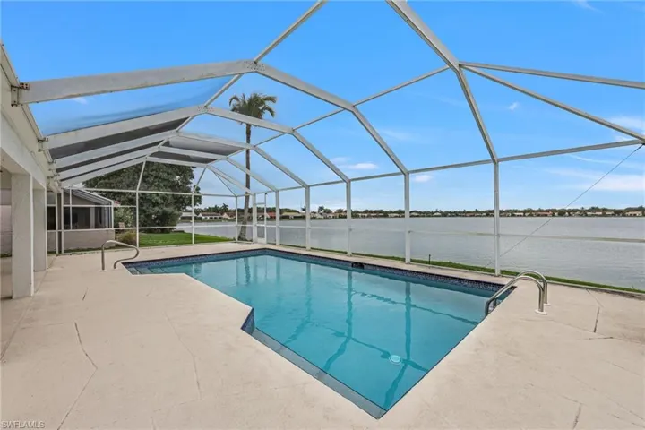 Outdoor pool featuring a sunroom, a lanai, a water view, and a patio area