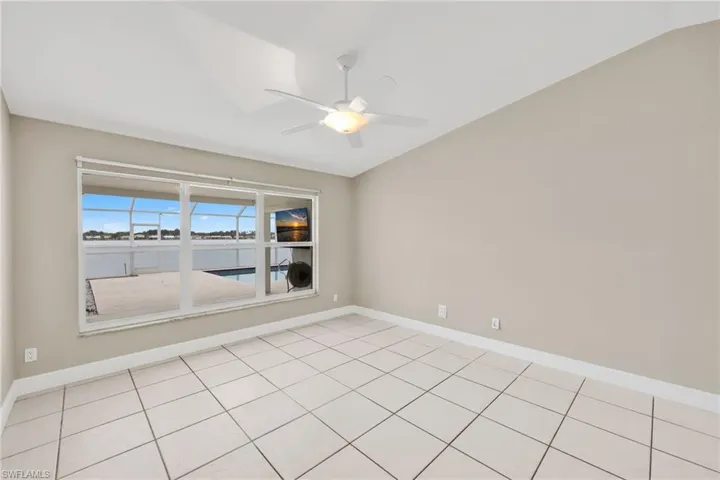 Empty room featuring vaulted ceiling and a ceiling fan