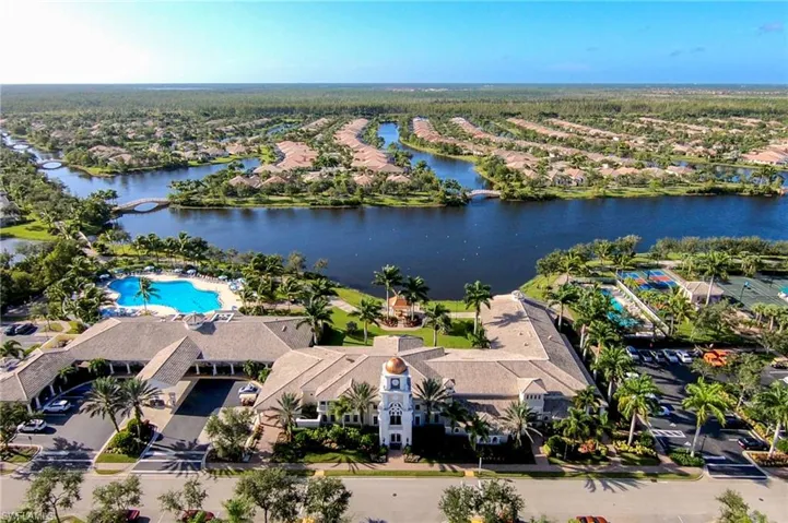 Aerial perspective of suburban area featuring a large body of water and a pool area