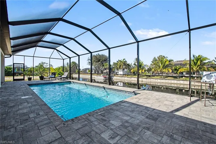 Swimming pool featuring a lanai, a patio, and a water view