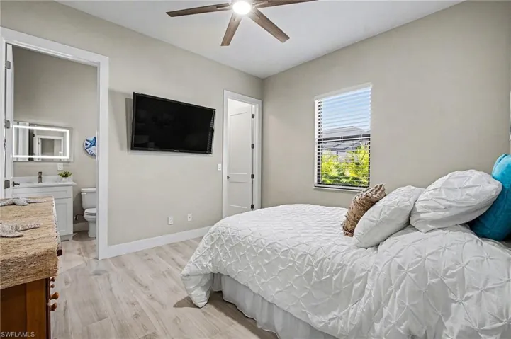 Bedroom with light wood finished floors and a ceiling fan