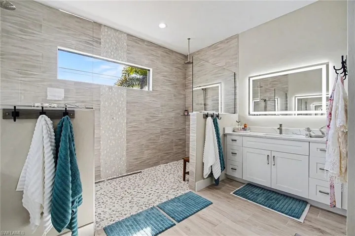 Master Bathroom featuring vanity, a walk in shower, and light wood-style flooring