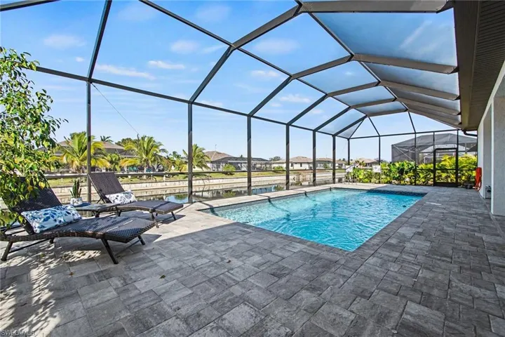 Swimming pool with a sunroom, a lanai, a residential view, and a patio