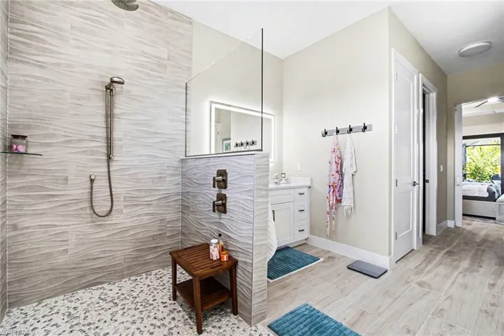 Master bathroom with walk in shower, vanity, and light wood-type flooring