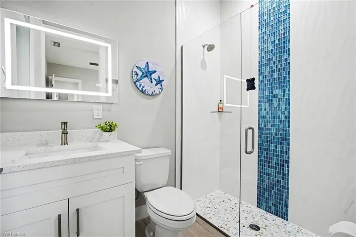 Guest Bathroom featuring a stall shower and vanity