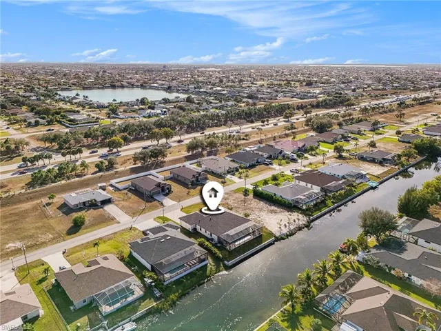 Aerial view of property's location with nearby suburban area and a nearby body of water
