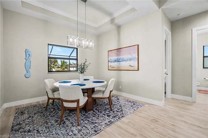 Dining room with light wood finished floors and ornamental molding