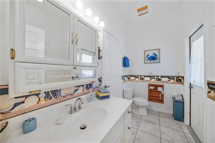 Bathroom with vanity, toilet, and tile patterned flooring