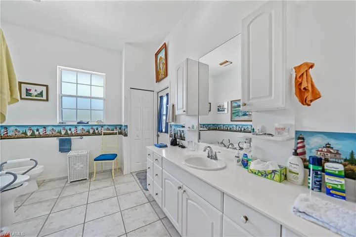 Bathroom featuring tile patterned flooring, vanity, toilet, a bidet, and a textured ceiling