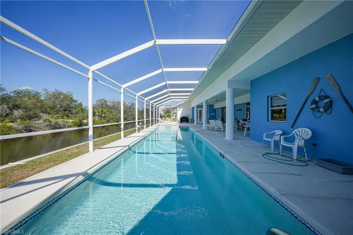 View of pool featuring a lanai, a patio, and a water view