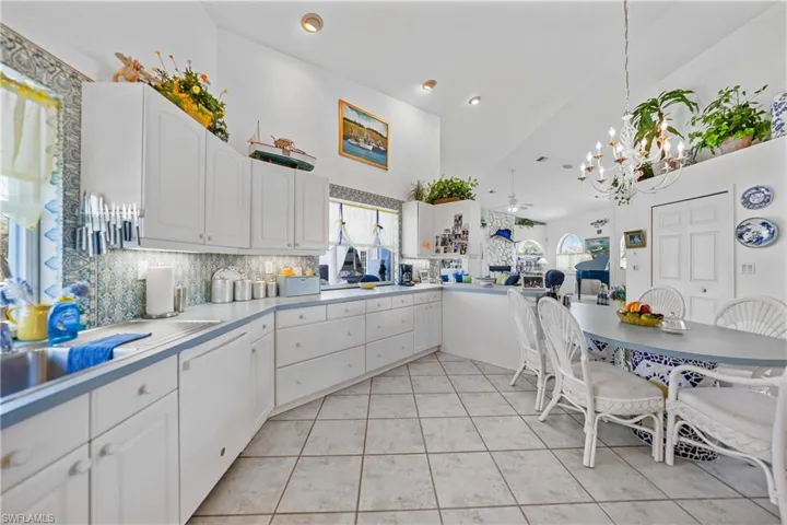 Kitchen featuring white cabinetry, dishwasher, tasteful backsplash, and a wealth of natural light