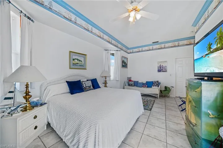 Bedroom with light tile patterned flooring and ceiling fan