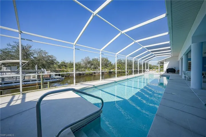 View of swimming pool with a water view, a lanai, and a patio area