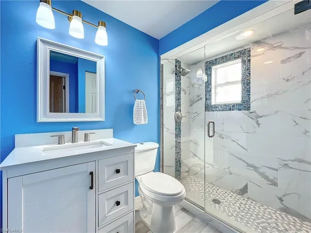Bathroom with walk in shower, vanity, and toilet