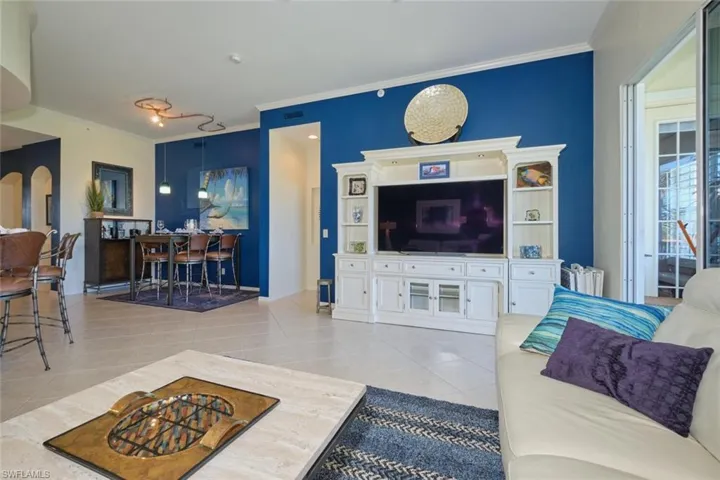 Tiled living room featuring crown molding