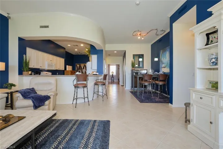 Living room with light tile patterned flooring and crown molding